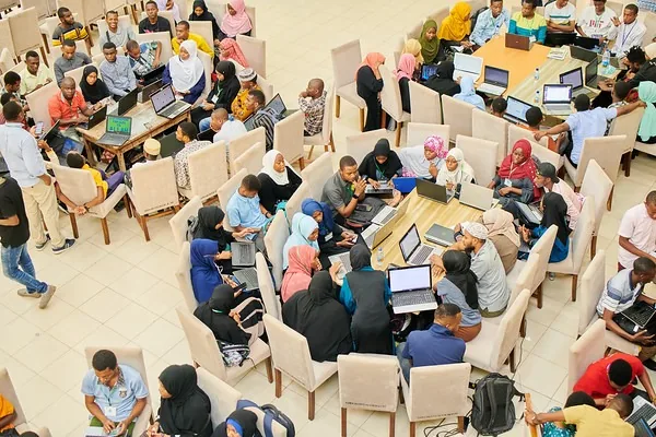 A packed workshop hall of participants working on laptops